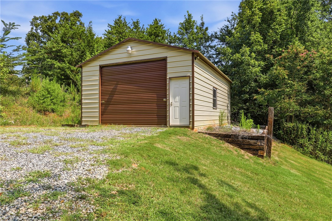1110 Sunset Lane Anderson, SC 29626 - Photo 32 of 38 Metal-clad utility building with a large roll-up door offers practical storage.