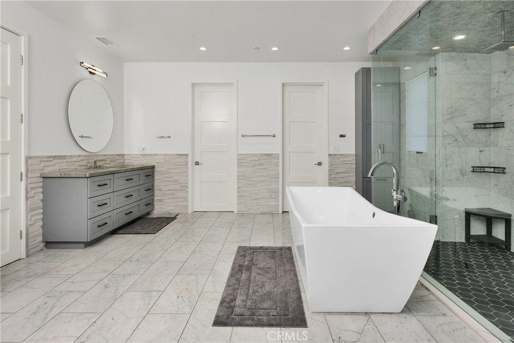 16582 Rio Vista Road San Diego, CA 92127 - Photo 20 of 49 a spacious bathroom with a double vanity sink a mirror and a shower