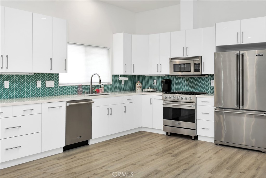 16582 Rio Vista Road San Diego, CA 92127 - Photo 42 of 49 a kitchen with cabinets stainless steel appliances and wooden floor