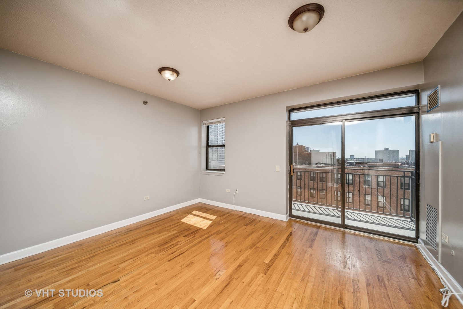 1529 South State Street, Unit 11F Chicago, IL 60605 - Photo 2 of 14 an empty room with wooden floor and windows