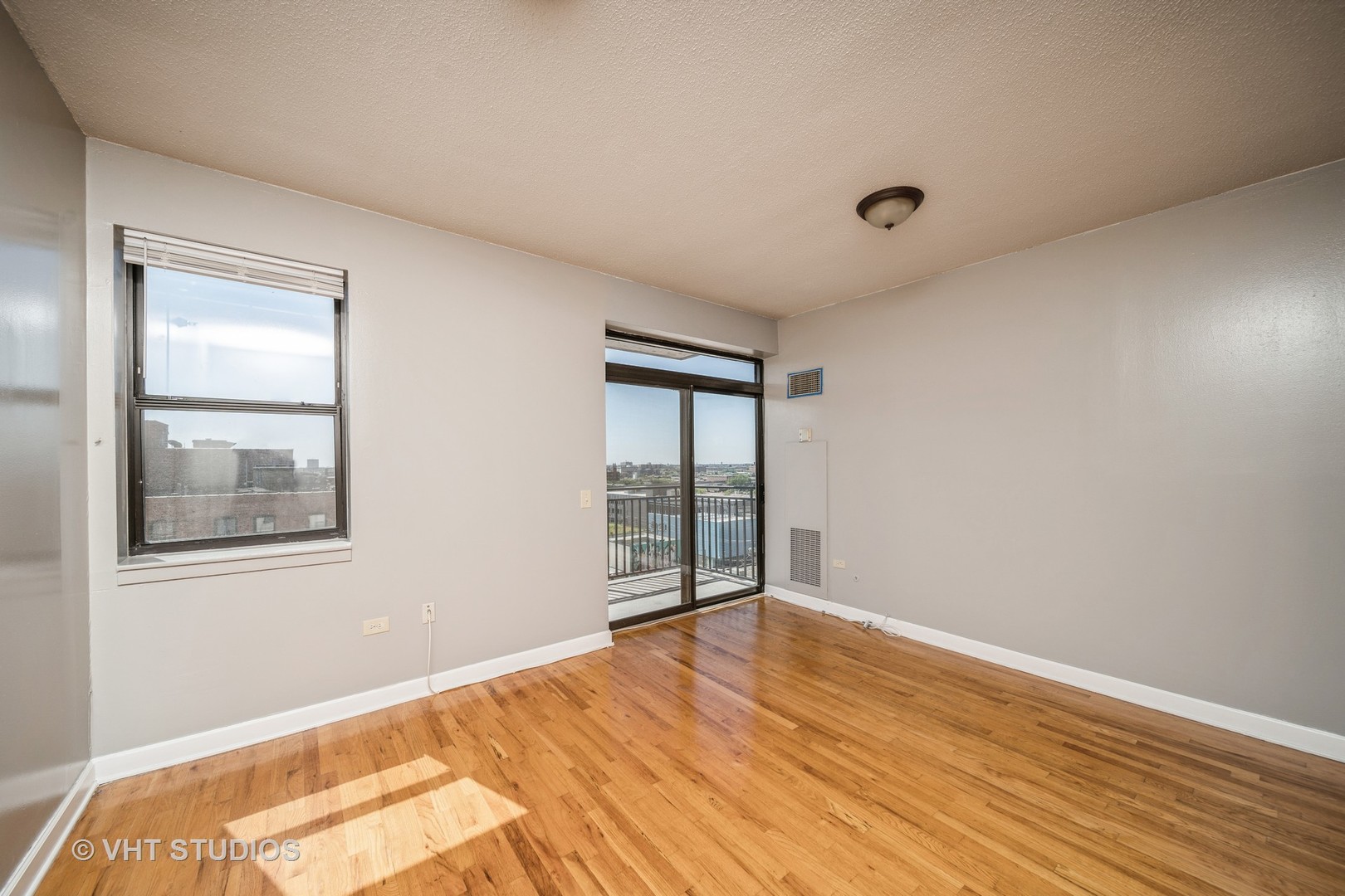 1529 South State Street, Unit 11F Chicago, IL 60605 - Photo 4 of 14 an empty room with wooden floor and windows