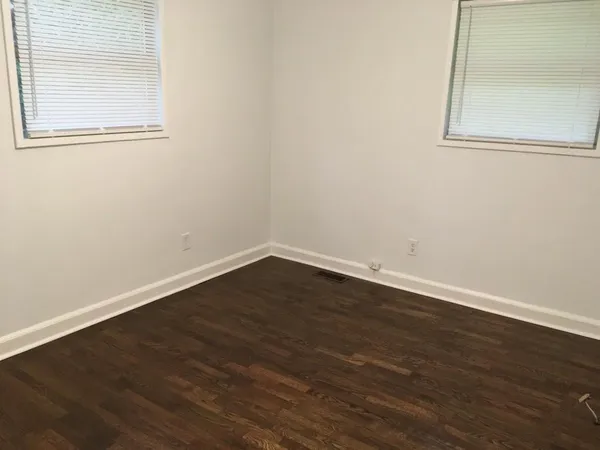 a view of a small space with wooden floor and a window