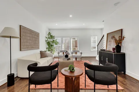 a living room with furniture and a wooden floor