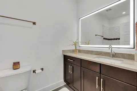 a bathroom with a granite countertop sink and a mirror
