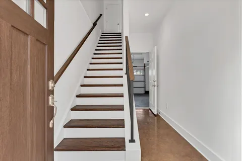 a view of entryway with wooden floor and stairs