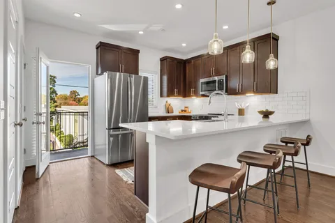 a kitchen with stainless steel appliances granite countertop a refrigerator and a stove top oven