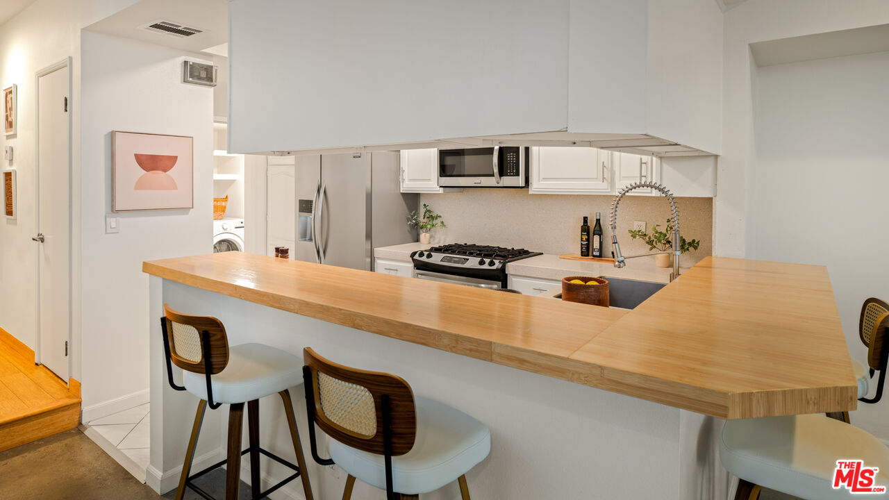 10627 Ashton Avenue, Unit 103 Los Angeles, CA 90024 - Photo 11 of 25 a kitchen with stainless steel appliances granite countertop a sink and cabinets