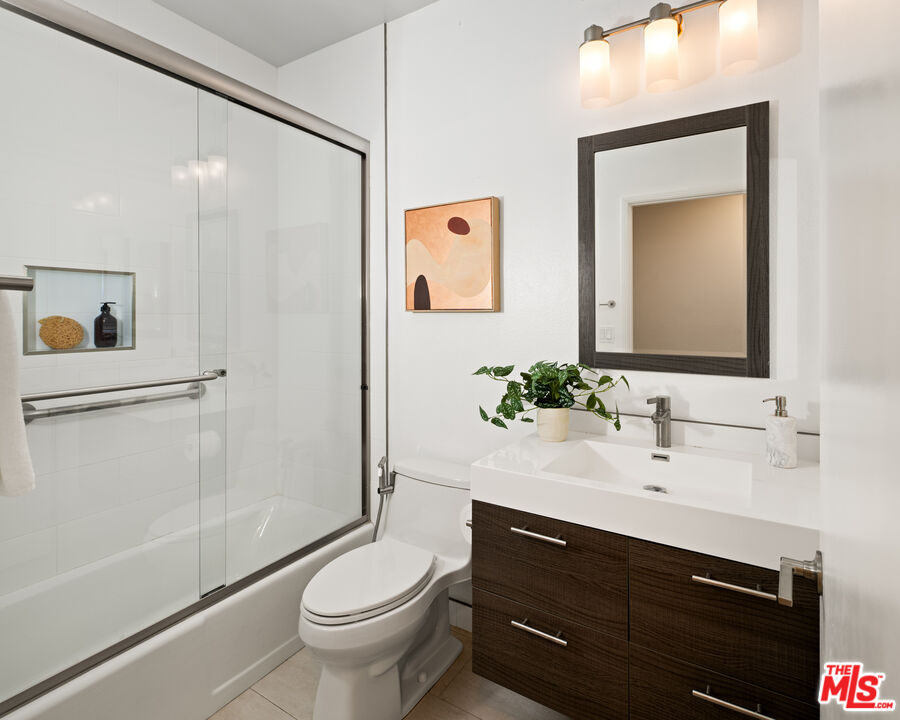 10627 Ashton Avenue, Unit 103 Los Angeles, CA 90024 - Photo 24 of 25 a bathroom with a sink a toilet a mirror and shower