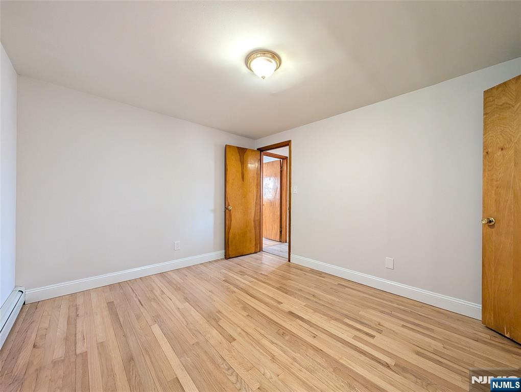 762 Cleveland Avenue, Unit 2 Harrison, NJ 07029 - Photo 11 of 14 a view of an empty room with wooden floor and a window