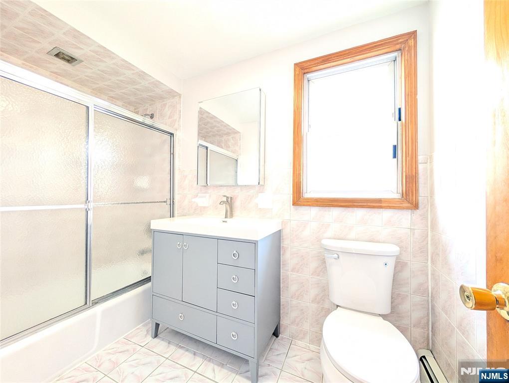 762 Cleveland Avenue, Unit 2 Harrison, NJ 07029 - Photo 14 of 14 a bathroom with a toilet a sink and a mirror