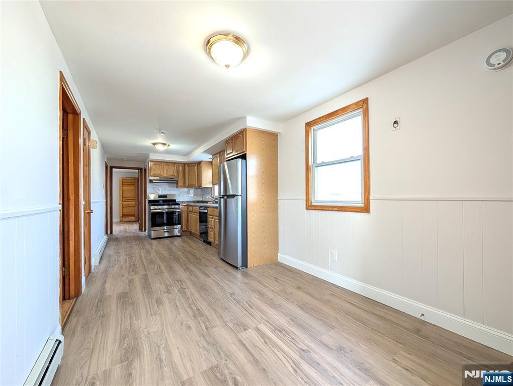 762 Cleveland Avenue, Unit 2 Harrison, NJ 07029 - Photo 4 of 14 a view of a kitchen with wooden floor electronic appliances and windows