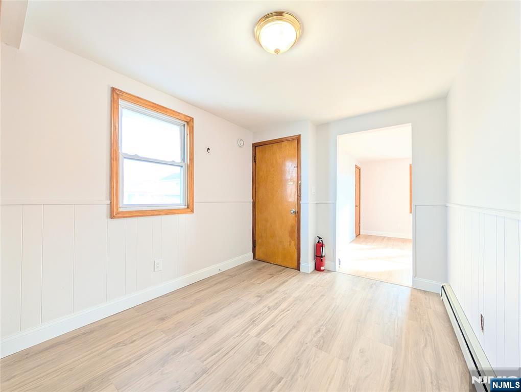 762 Cleveland Avenue, Unit 2 Harrison, NJ 07029 - Photo 5 of 14 an empty room with wooden floor and windows