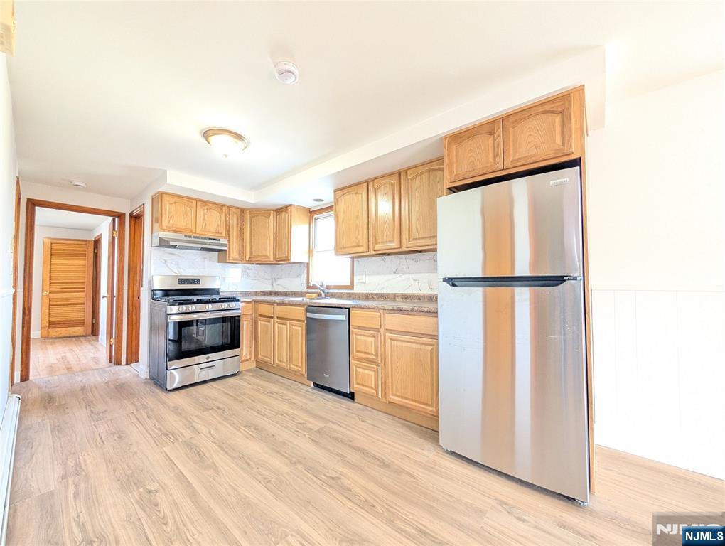 762 Cleveland Avenue, Unit 2 Harrison, NJ 07029 - Photo 6 of 14 a kitchen with a refrigerator a stove top oven and kitchen island