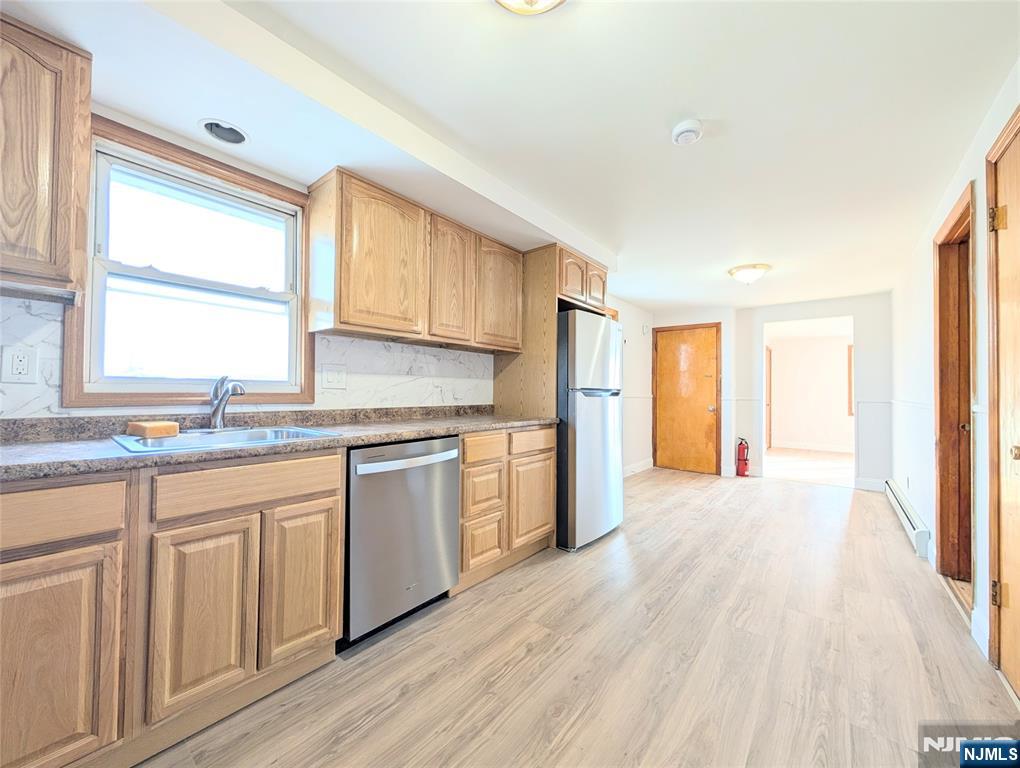 762 Cleveland Avenue, Unit 2 Harrison, NJ 07029 - Photo 7 of 14 a kitchen with granite countertop a stove a sink and a refrigerator with wooden floors
