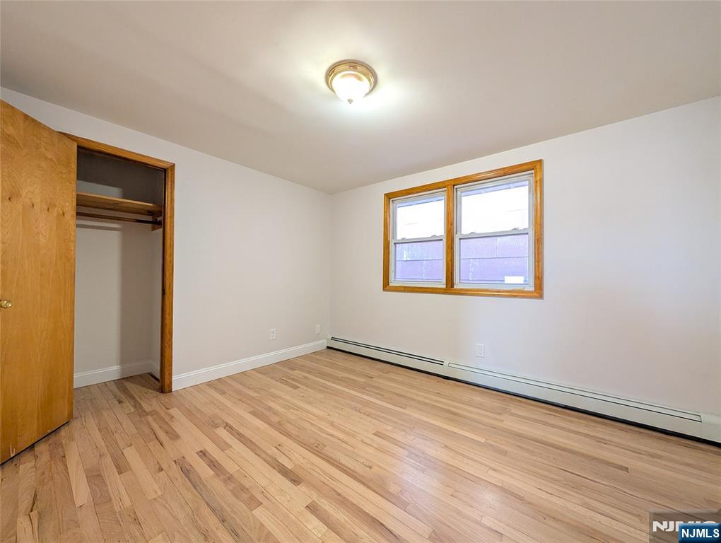 762 Cleveland Avenue, Unit 2 Harrison, NJ 07029 - Photo 10 of 14 a view of an empty room with wooden floor and a window