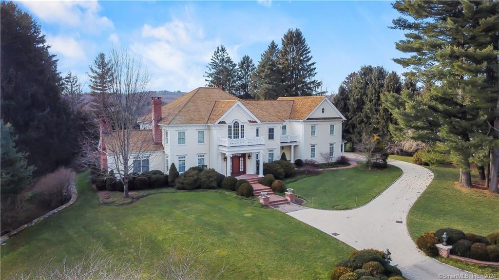 28 Riding Club Road Wilton, CT 06897 - Photo 1 of 1 a view of a white house next to a yard with plants and trees
