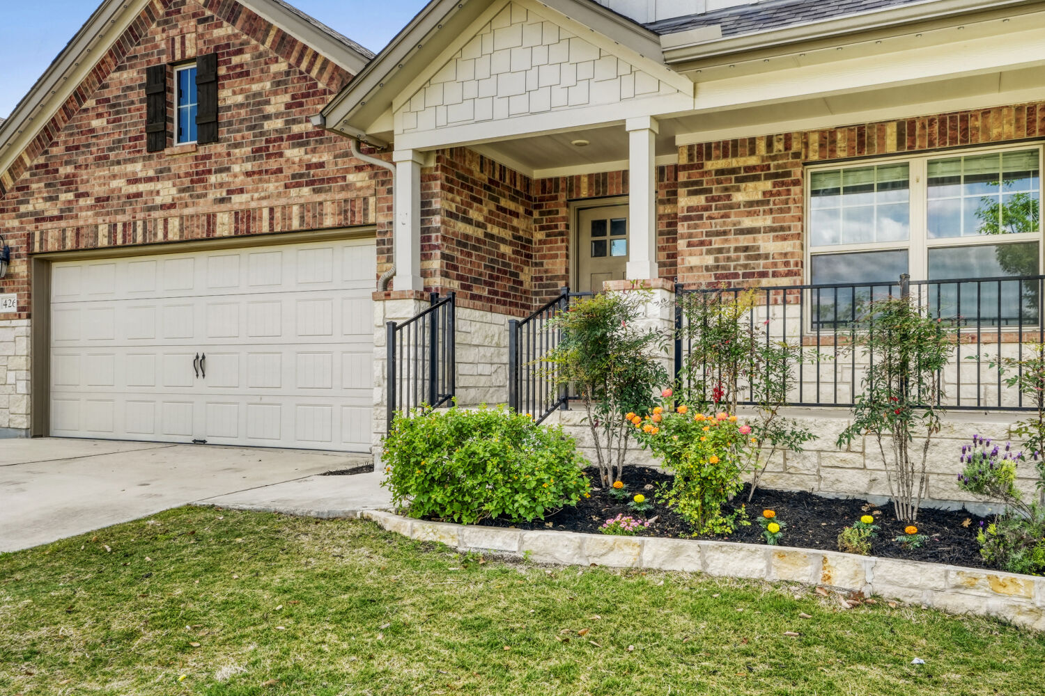 426 Cold Riv Run Kyle, TX 78640 - Photo 3 of 24 View of front of home with covered front porch, front beds, with brick and stone masonry