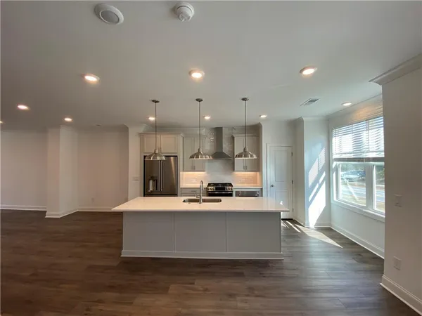 a large kitchen with stainless steel appliances a large counter top