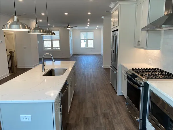a kitchen with stainless steel appliances granite countertop a sink a stove and a refrigerator