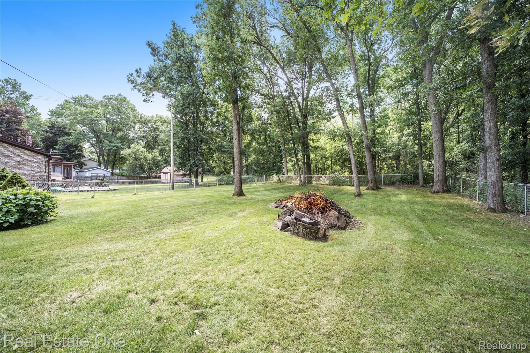 9069 Clark Road Clarkston, MI 48346 - Photo 49 of 51 Did someone say bonfire? The lots is fully fenced, but extends well past the fence. It is wooded, and leads to a 200 acre nature preserve. Beautiful!