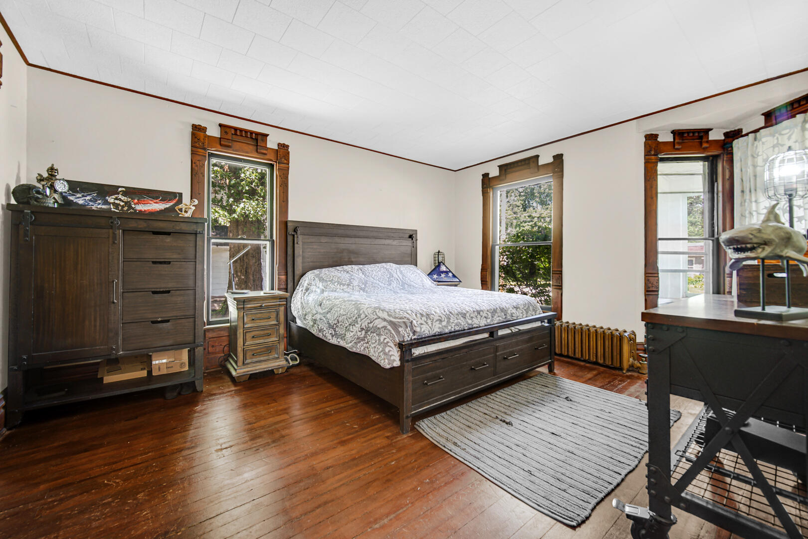 448 North Weston Street Rensselaer, IN 47978 - Photo 11 of 28 a bed sitting in a bedroom next to a window with chair and wooden floor