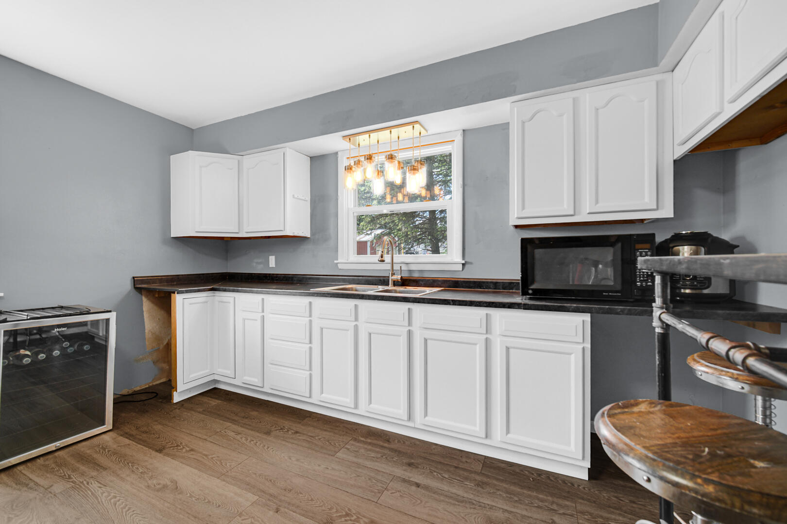 448 North Weston Street Rensselaer, IN 47978 - Photo 21 of 28 a kitchen with granite countertop a stove a sink dishwasher and white cabinets with wooden floor