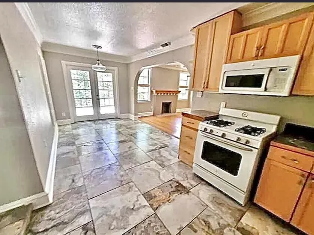 a kitchen with stainless steel appliances granite countertop a stove a sink and a microwave