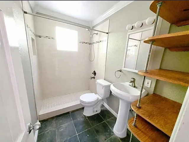 a bathroom with a toilet sink and shower