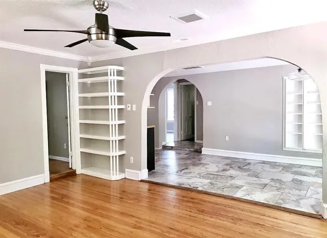 a view of empty room with wooden floor and window