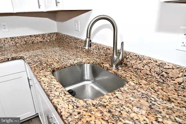 a close view of a sink a faucet and appliance in the kitchen