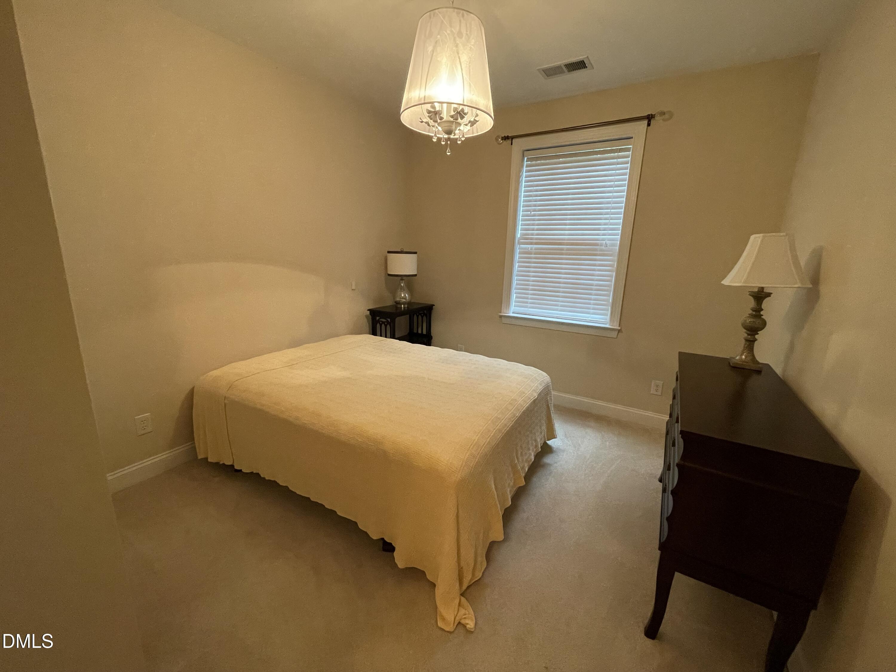 10411 Rosegate Court, Unit 3 Raleigh, NC 27617 - Photo 37 of 62 a bedroom with a bed and a chandelier