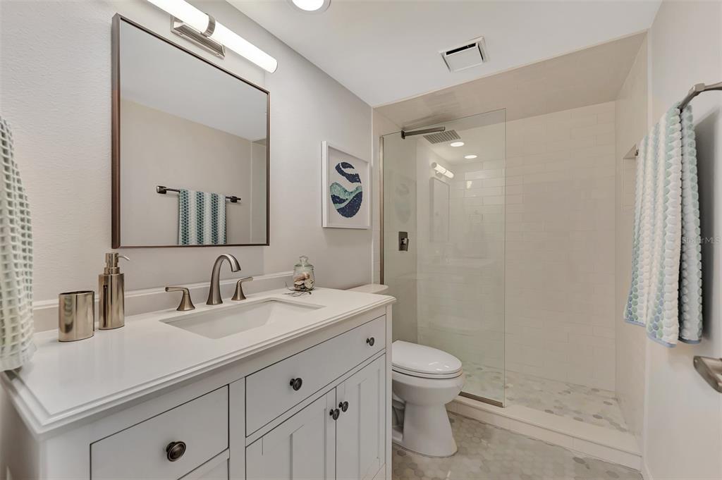 2950 North Beach Road, Unit A315 Englewood, FL 34223 - Photo 31 of 64 a bathroom with a sink a toilet a mirror and shower