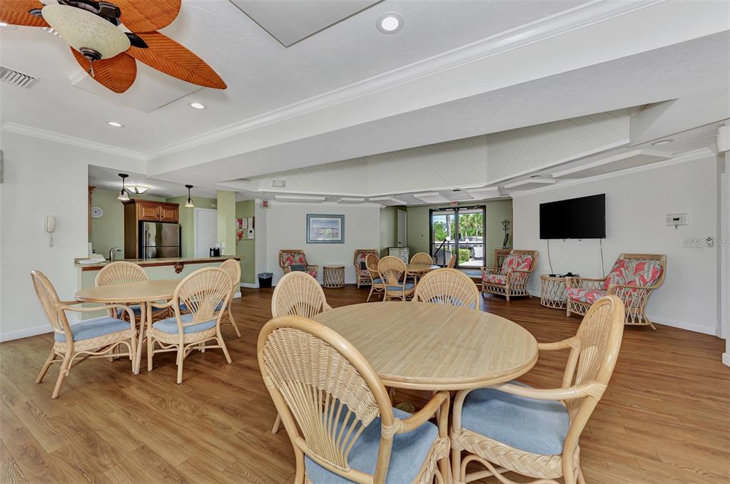 2950 North Beach Road, Unit A315 Englewood, FL 34223 - Photo 43 of 64 a dining room with furniture a flat screen tv and a rug