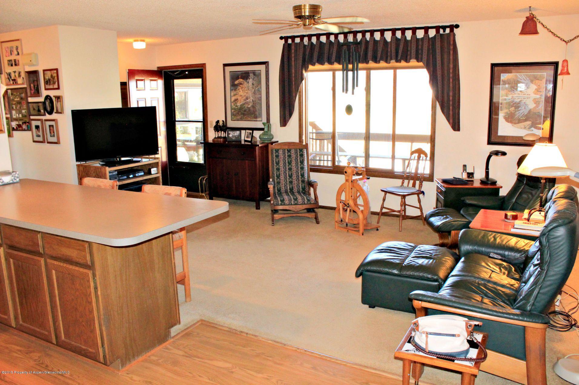 1018 County Road 294 Rifle, CO 81650 - Photo 4 of 31 a living room with furniture a flat screen tv and a floor to ceiling window