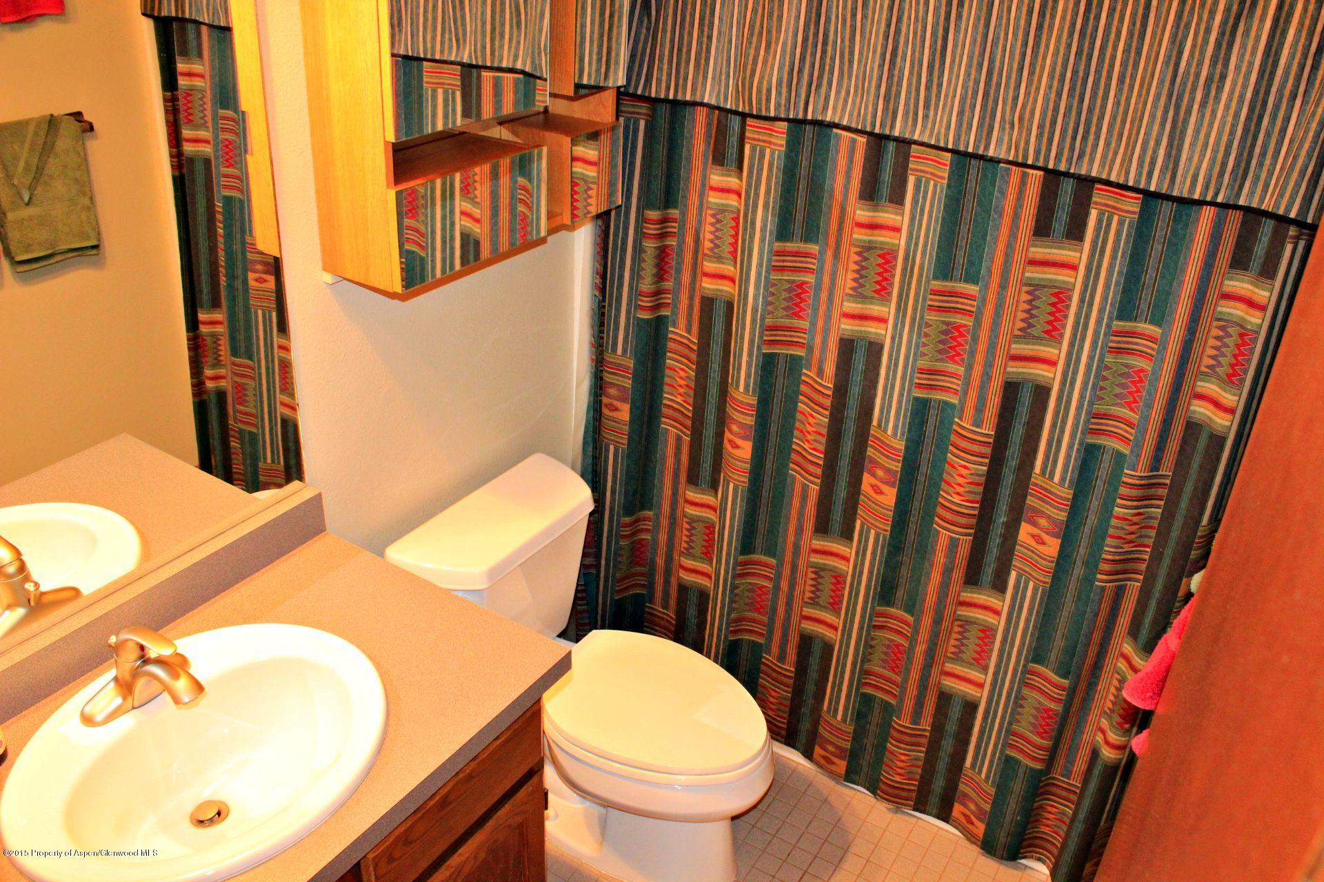 1018 County Road 294 Rifle, CO 81650 - Photo 9 of 31 a white toilet sitting next to a bathroom sink and a mirror