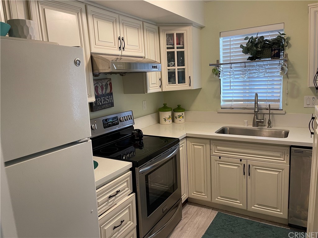 7641 Reseda Boulevard, Unit 118 Reseda, CA 91335 - Photo 7 of 16 a kitchen with stainless steel appliances a sink stove and cabinets