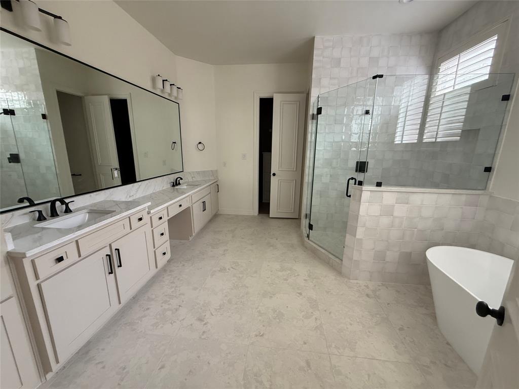 5312 Tennington Park Dallas, TX 75287 - Photo 16 of 19 a spacious bathroom with a double vanity sink a large mirror and a bathtub