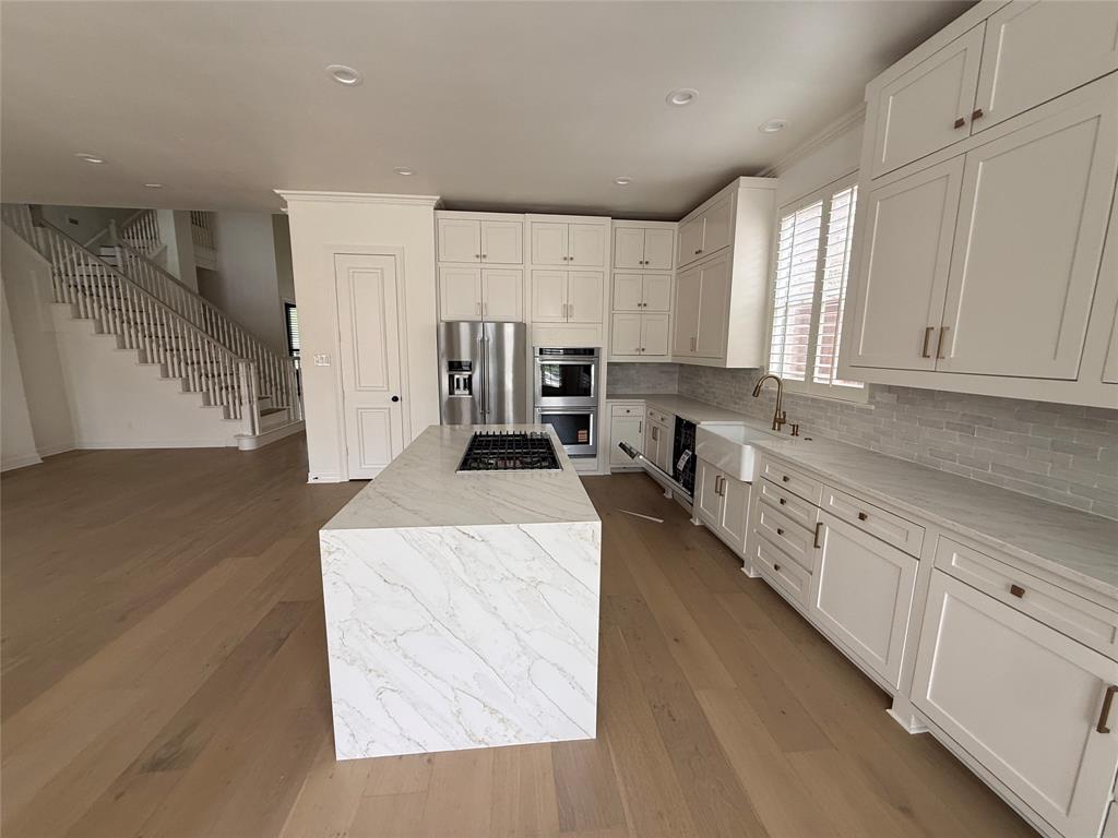 5312 Tennington Park Dallas, TX 75287 - Photo 9 of 19 a large white kitchen with granite countertop a sink a stove a dining table and chairs