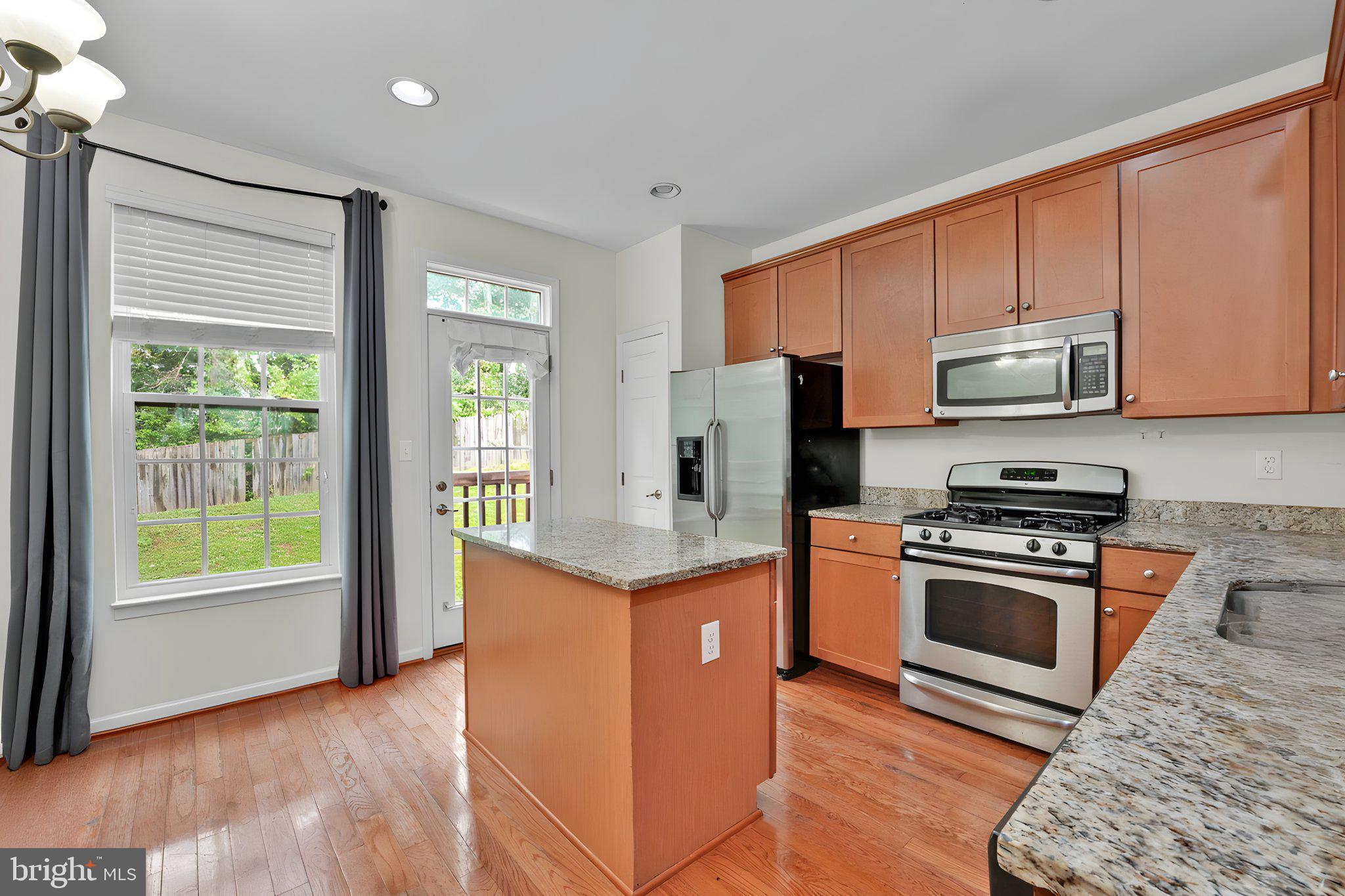 7138 Station House Road Elkridge, MD 21075 - Photo 24 of 42 a kitchen with stainless steel appliances granite countertop a stove a refrigerator and a microwave