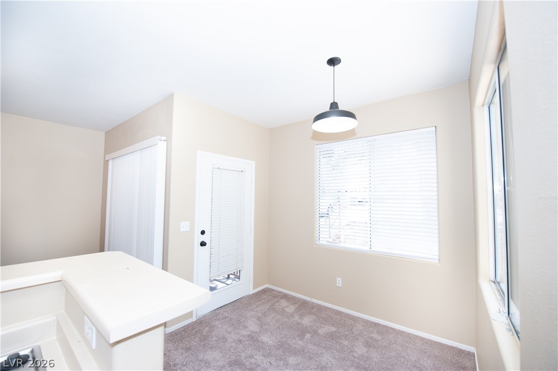 9050 West Warm Springs Road, Unit 1132 Las Vegas, NV 89148 - Photo 10 of 21 A well-lit area featuring plush carpeting and a modern pendant light fixture.