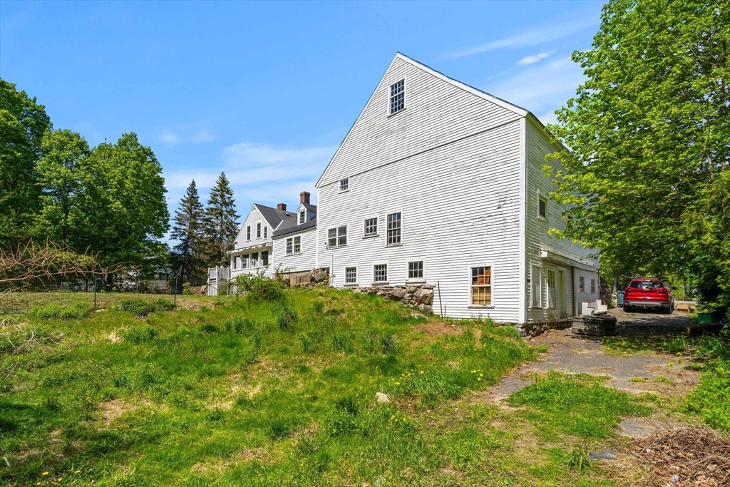 600 Main Street Ashby, MA 01431 - Photo 39 of 40 a view of a white house with a small yard and sitting area