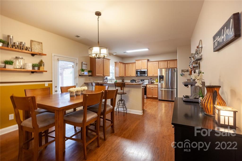 688 Winding Branch Road Rock Hill, SC 29732 - Photo 12 of 38 a view of a dining room and livingroom with furniture wooden floor a chandelier