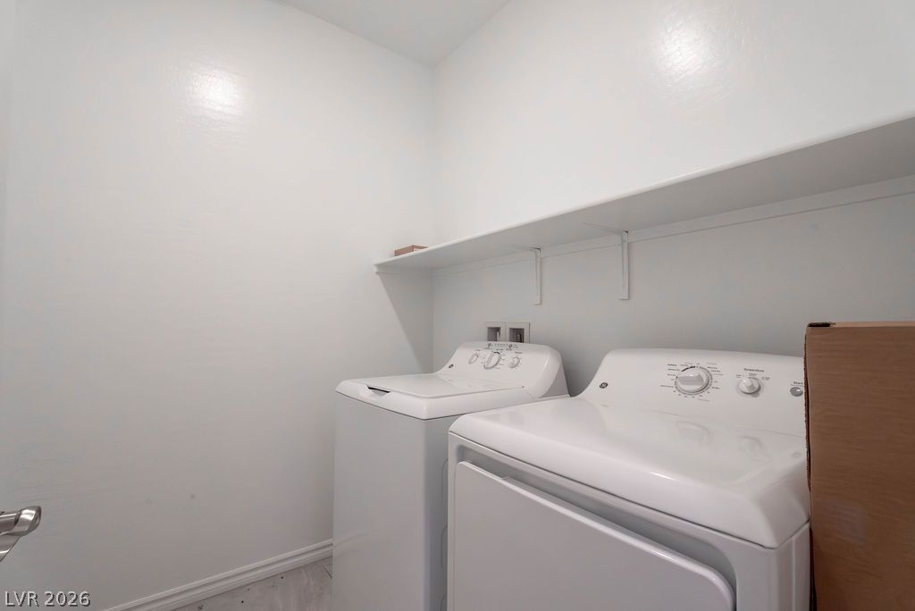 7126 Calvert Cliffs Street North Las Vegas, NV 89084 - Photo 19 of 44 Functional laundry room, equipped with a washer, dryer, and convenient overhead shelving for storage.