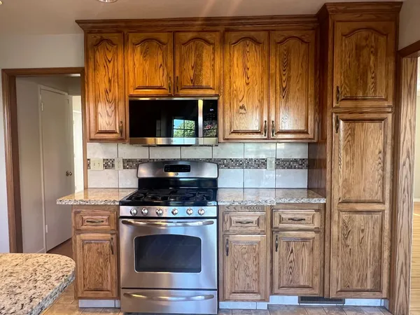a kitchen with granite countertop a stove and a microwave