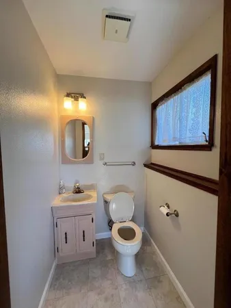a bathroom with a toilet sink and mirror