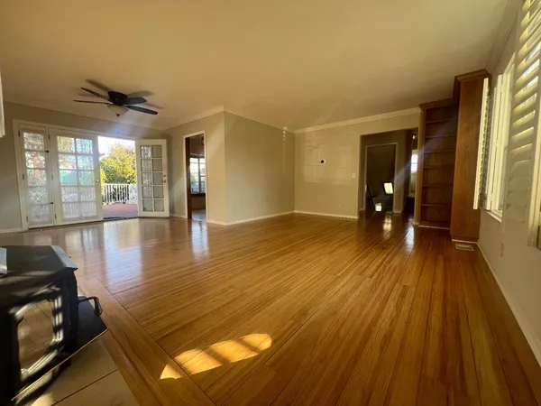 a view of empty room with wooden floor