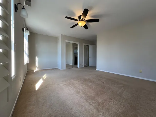 a view of an empty room with a ceiling fan