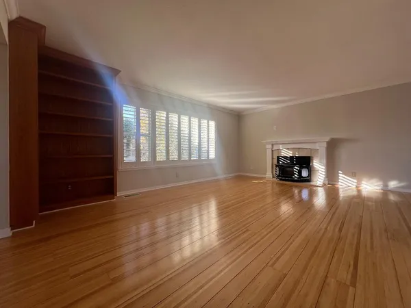 a view of empty room with wooden floor and fireplace