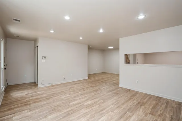 a view of an empty room with wooden floor