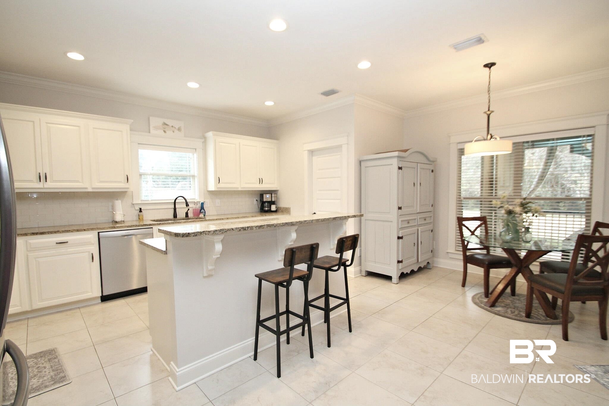 30232 Persimmon Drive Daphne, AL 36527 - Photo 7 of 27 Kitchen with light stone counters, a kitchen island, white cabinetry, hanging light fixtures, and stainless steel dishwasher